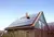 Haus mit Solaranlage auf dem Dach unter klarem Himmel